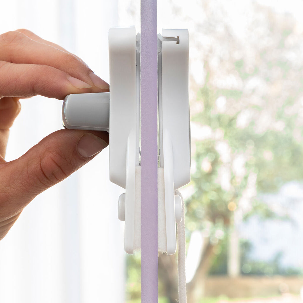 Side view of the Magnetic Window Cleaner in use, showing close contact with a glass pane. Emphasizes the magnetic attachment and cleaning effectiveness.