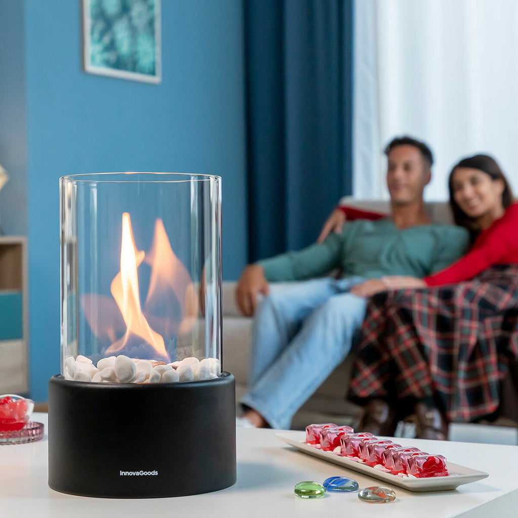 Lifestyle image of the fireplace on a coffee table in a cozy living room. A couple is sitting on the couch in the background, creating a warm ambiance.