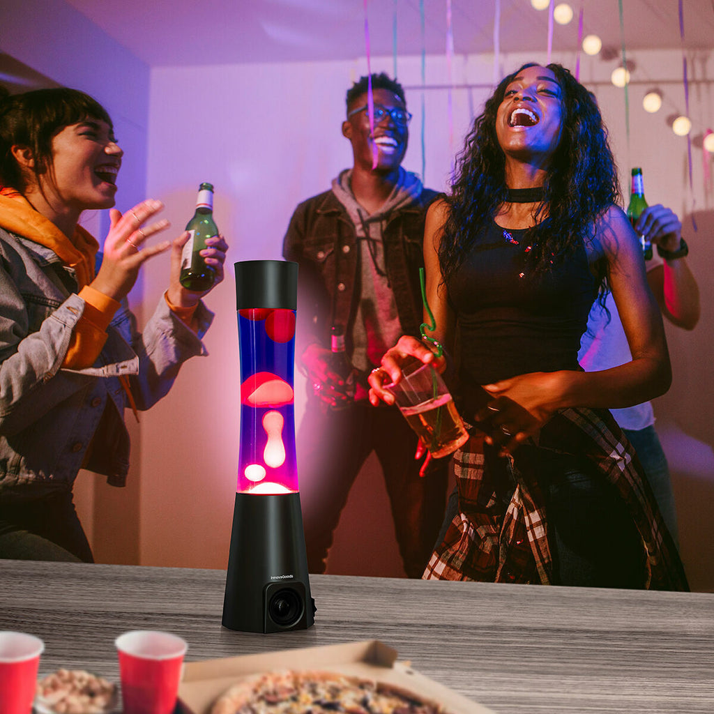 A lively party scene with the lava lamp in the foreground, providing colorful ambiance while people enjoy the event.