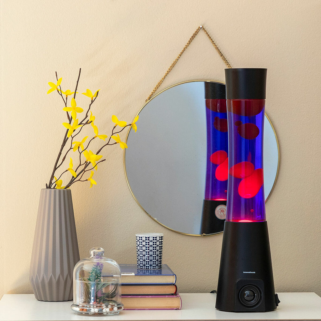 The lava lamp is part of a decorative setup on a shelf, with books and decorative items nearby, enhancing its aesthetic appeal.