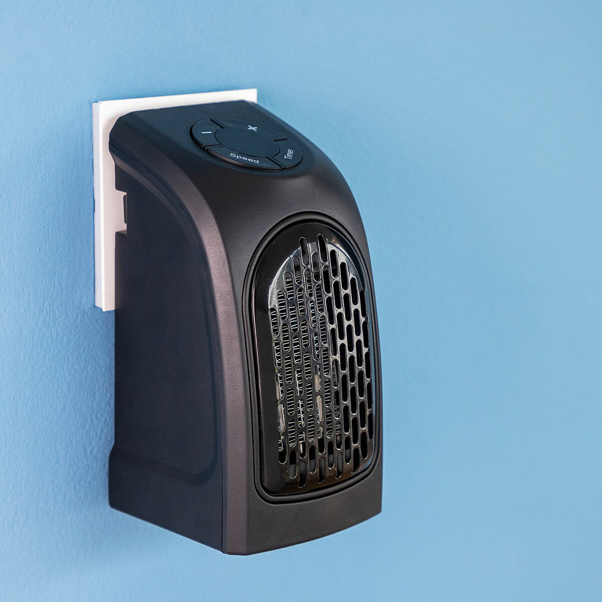 The heater is shown installed in a wall outlet against a blue wall, highlighting the compact and sleek design.