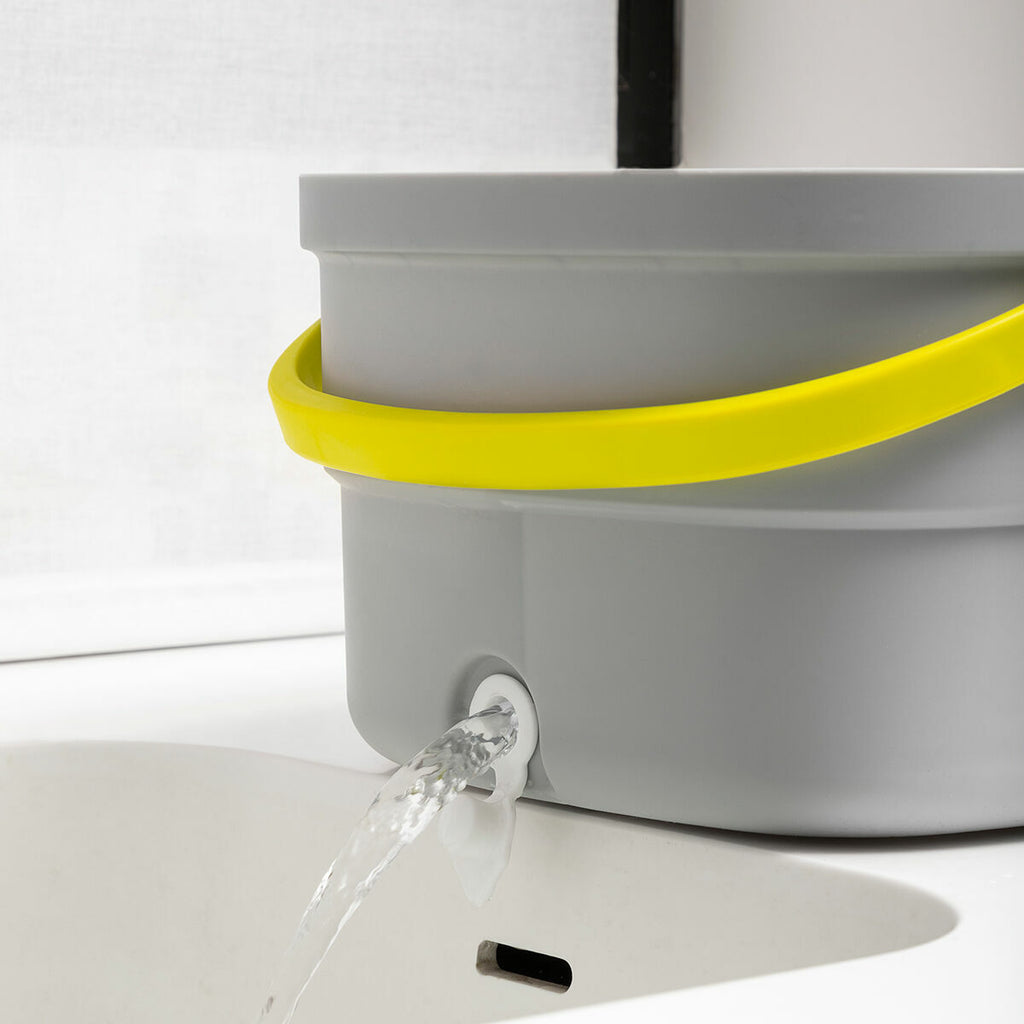 Close-up of the bucket's water drainage feature with water flowing out into a sink.