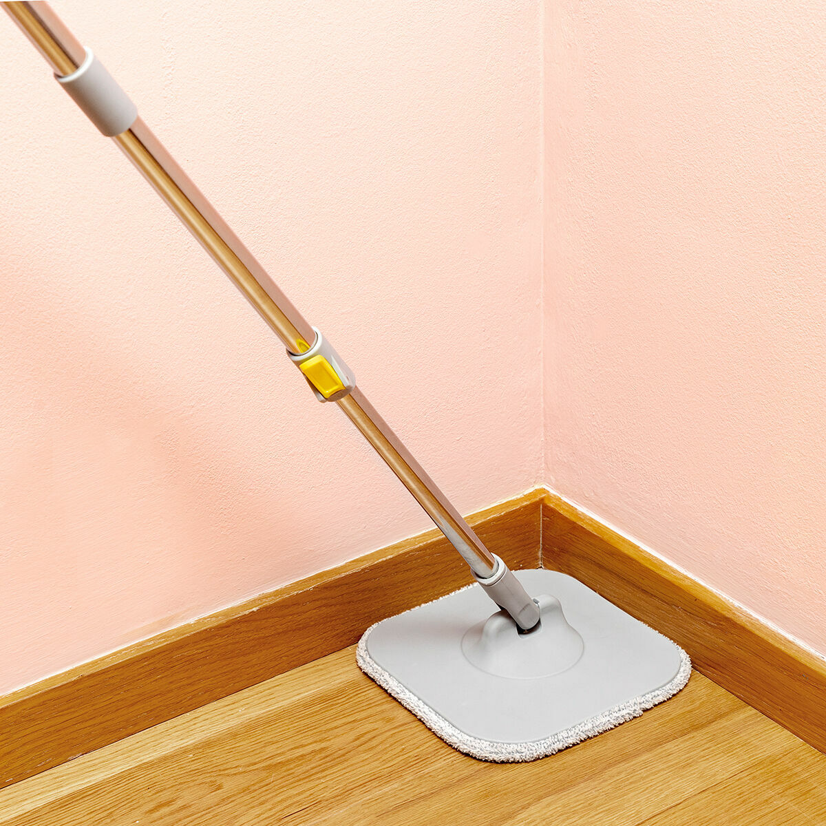 Mop in use cleaning a corner on a wooden floor, demonstrating maneuverability.