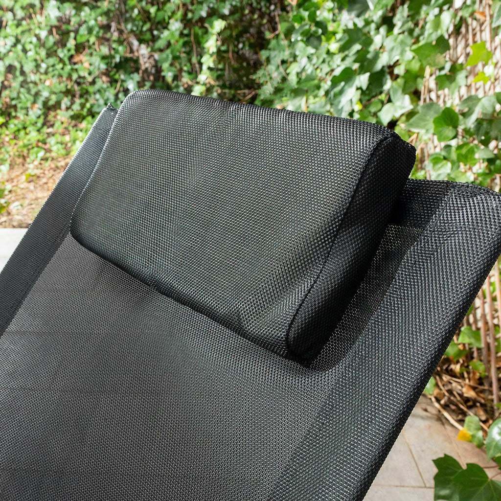 Close-up of the cushioned headrest part of the Rockorb sunbed, showing the black fabric texture and adjustable feature in a garden setting.