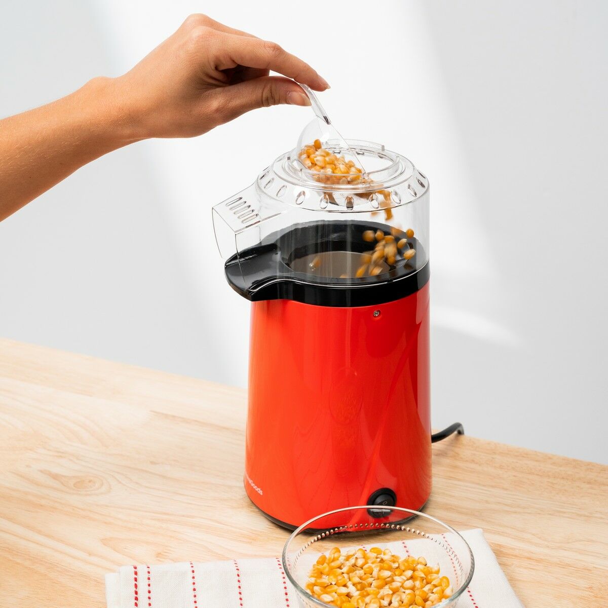Corn kernels being poured into the Hot Air Popcorn Maker Popmar InnovaGoods.