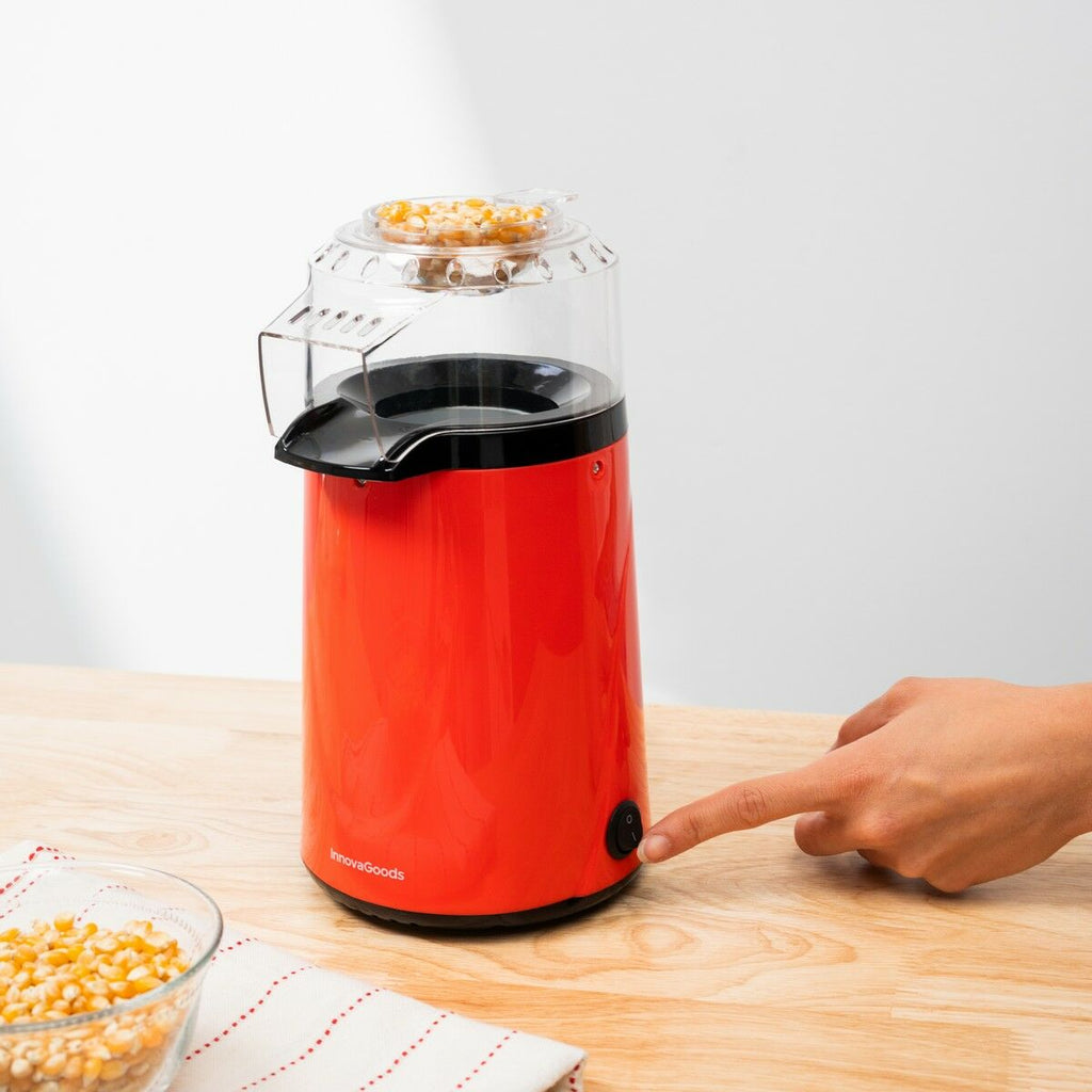 A hand pressing the button on the Hot Air Popcorn Maker Popmar InnovaGoods.