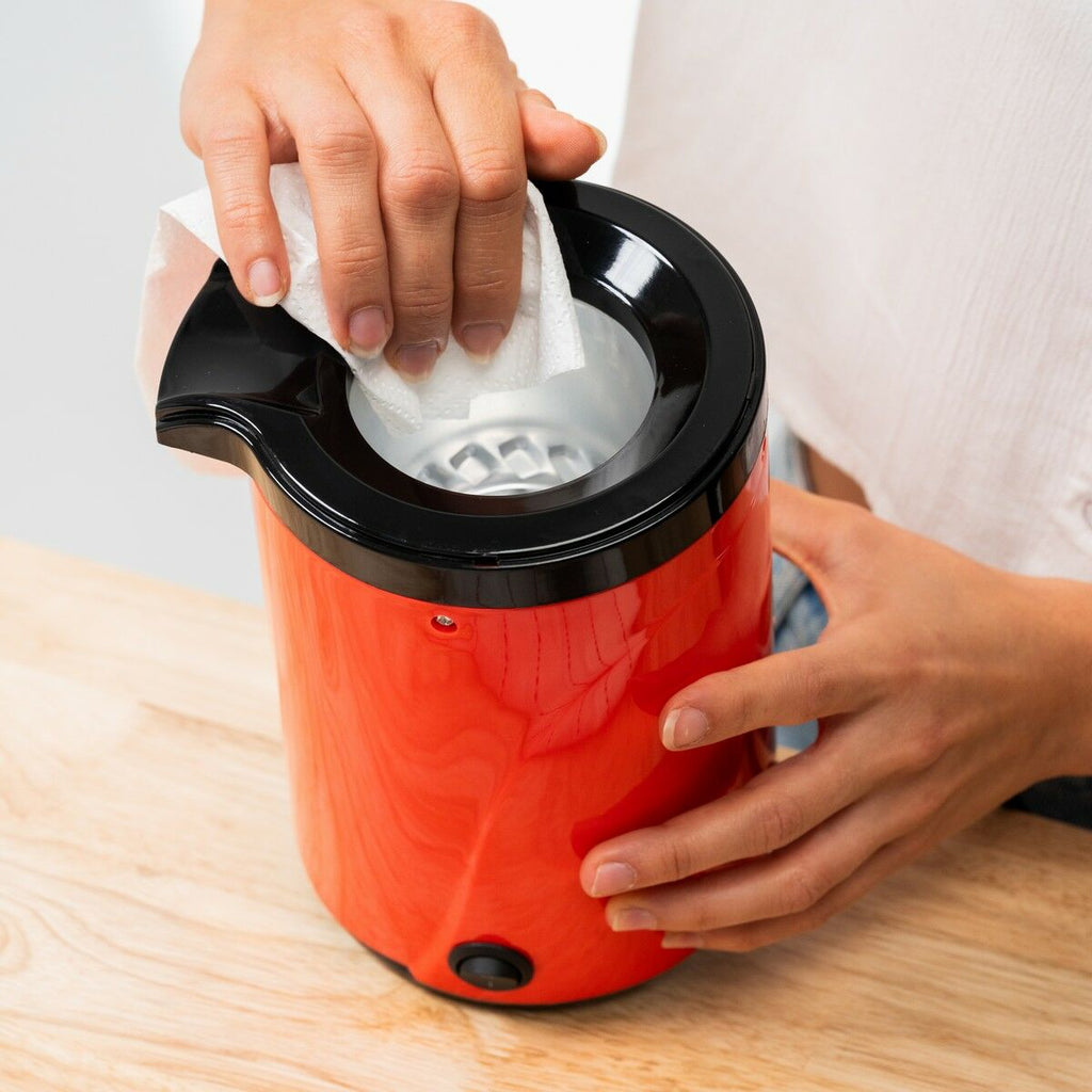 Close-up of the Hot Air Popcorn Maker Popmar InnovaGoods being cleaned with a cloth.