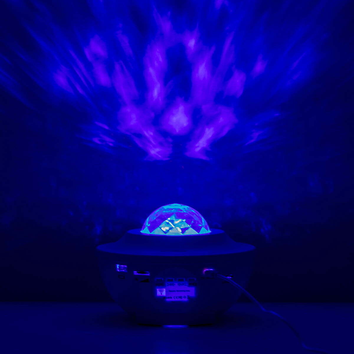 The projector shows a vivid blue and violet projection, emphasizing the variety of light patterns achievable with the device.
