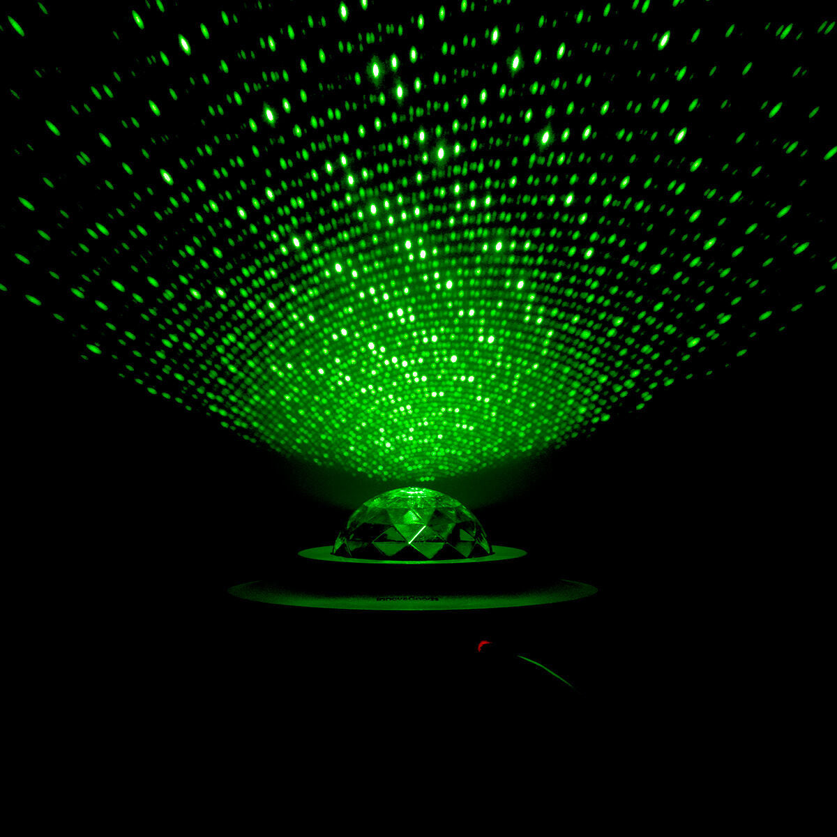 The projector's dome casts a green, starry light pattern in a dark environment, highlighting its capability to turn any room into a relaxing star-filled night sky.