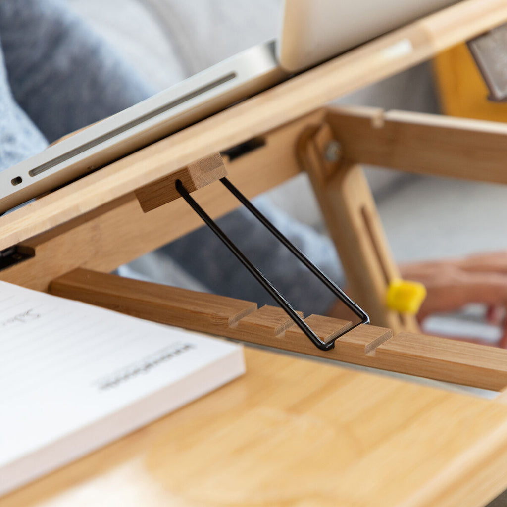 The bamboo table used as a desk setup with a laptop and mouse in a modern interior setting, highlighting its versatility.