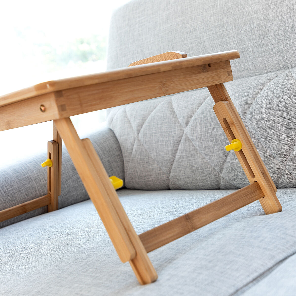 A close-up of the table's legs on a couch, highlighting the stability and wooden texture.