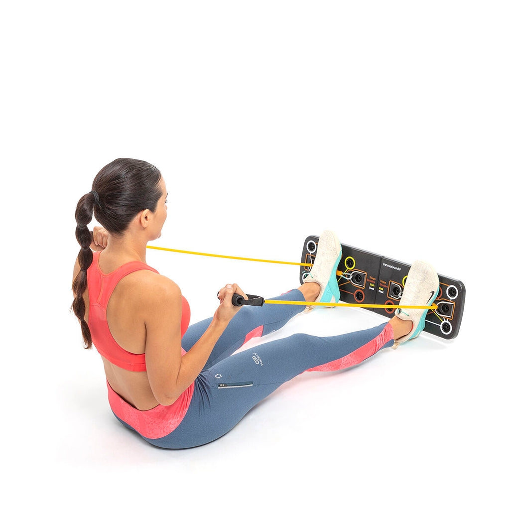 A person sitting and using the resistance bands attached to the push-up board for a seated exercise.