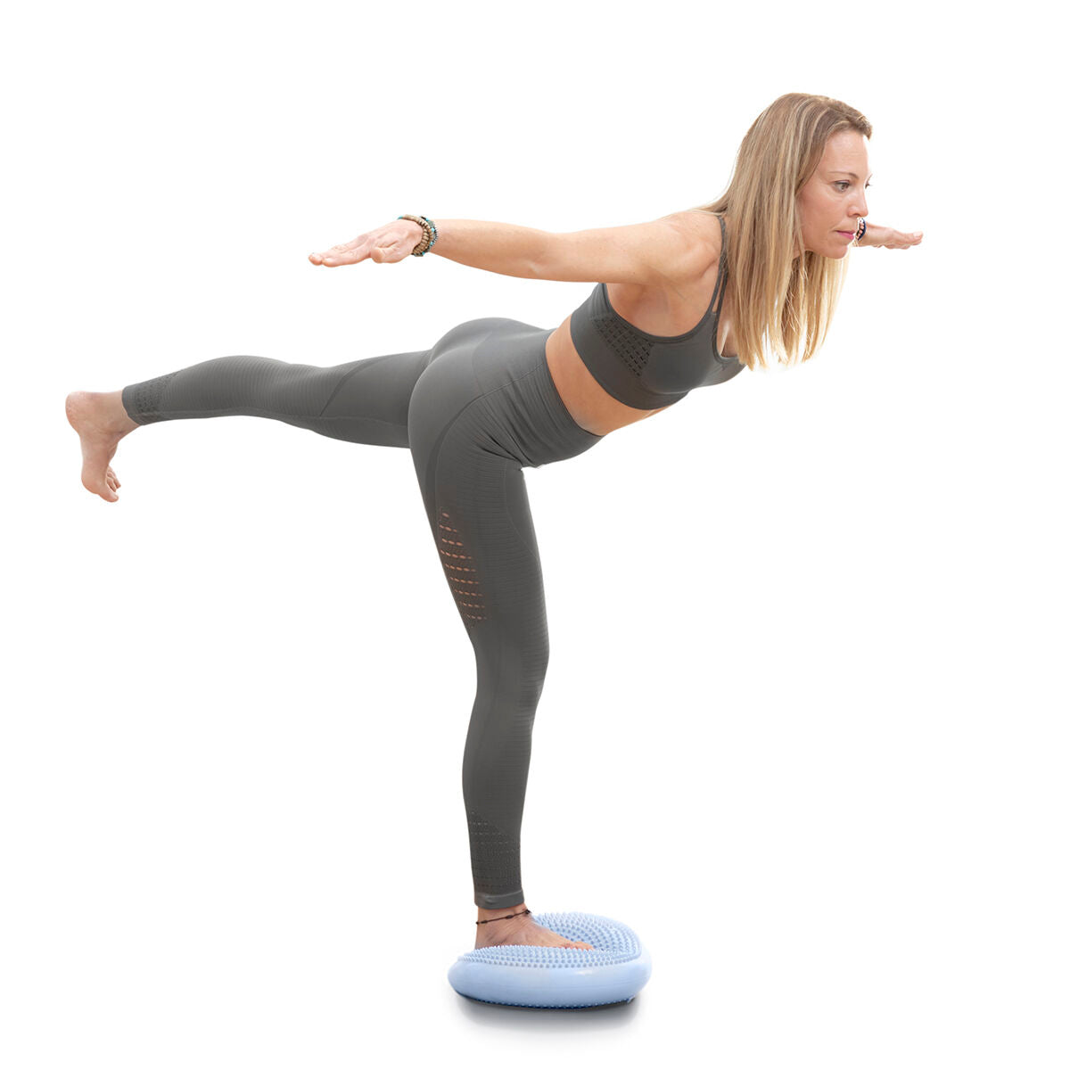 A woman balancing on one leg using the Cushport Balance Cushion, demonstrating its use for balance training and posture improvement.