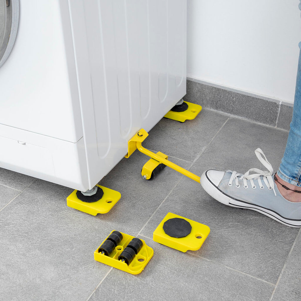 A close-up of a person using the 'HeavEasy Lifting and Moving Tool' foot lever beside a washing machine on a gray tile floor.