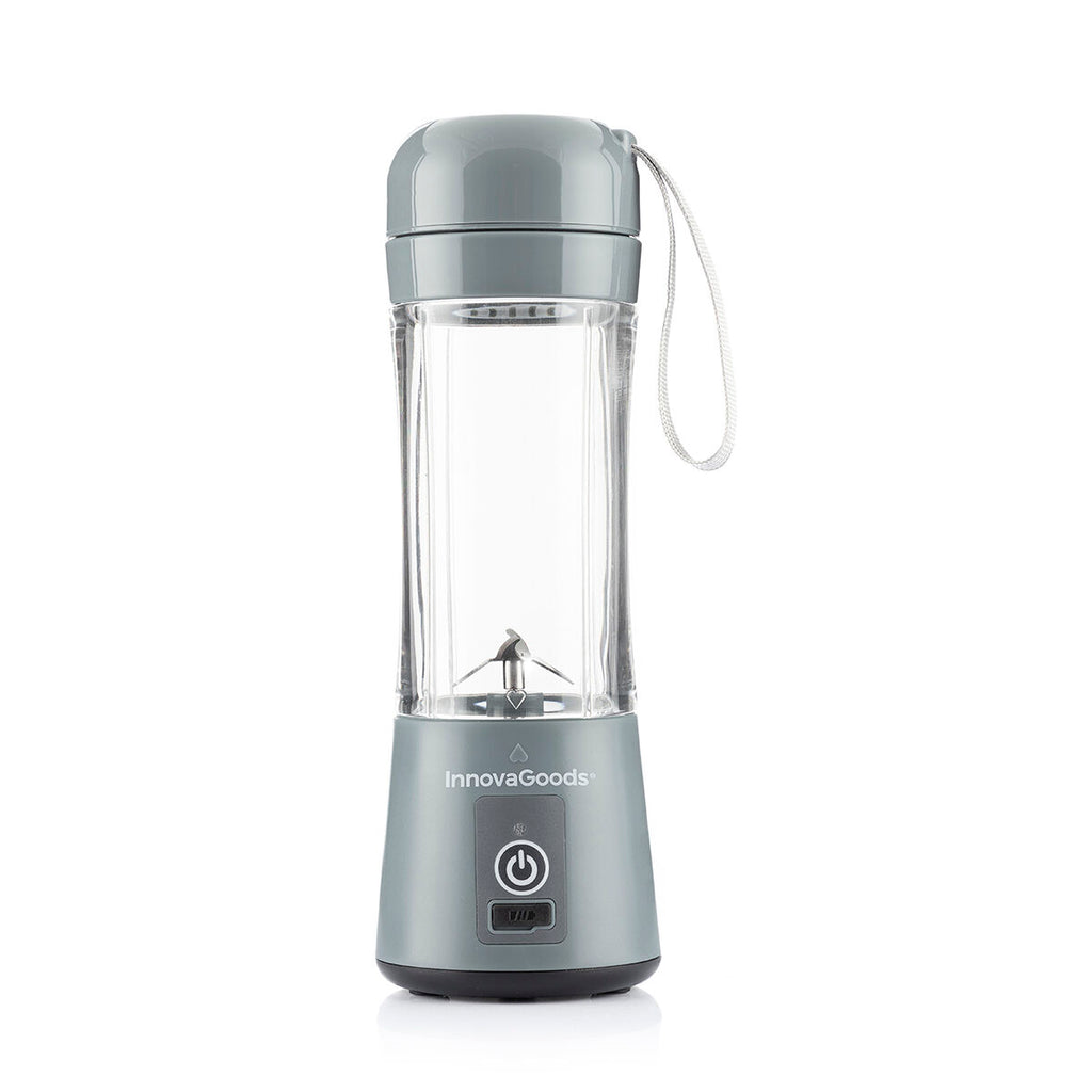 The product is shown empty, offering a clear view of the blender’s base and transparent cup. It has a gray lid with a strap, suitable for portability.