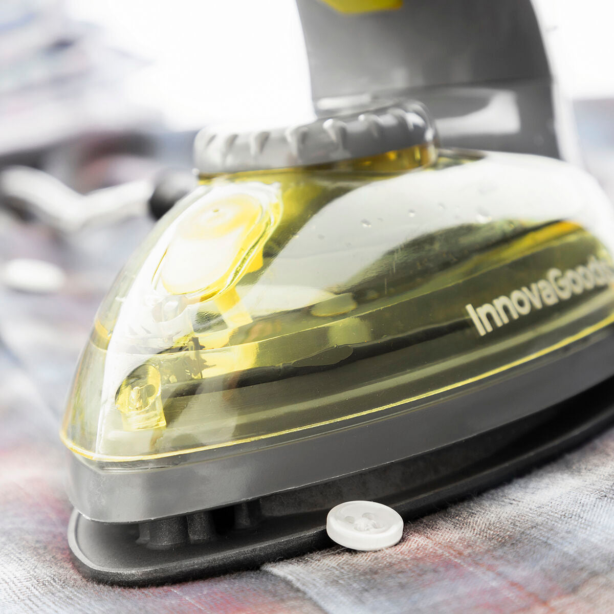 Close-up image showing the steam iron’s detailed construction and Innovagoods branding on a fabric layout.