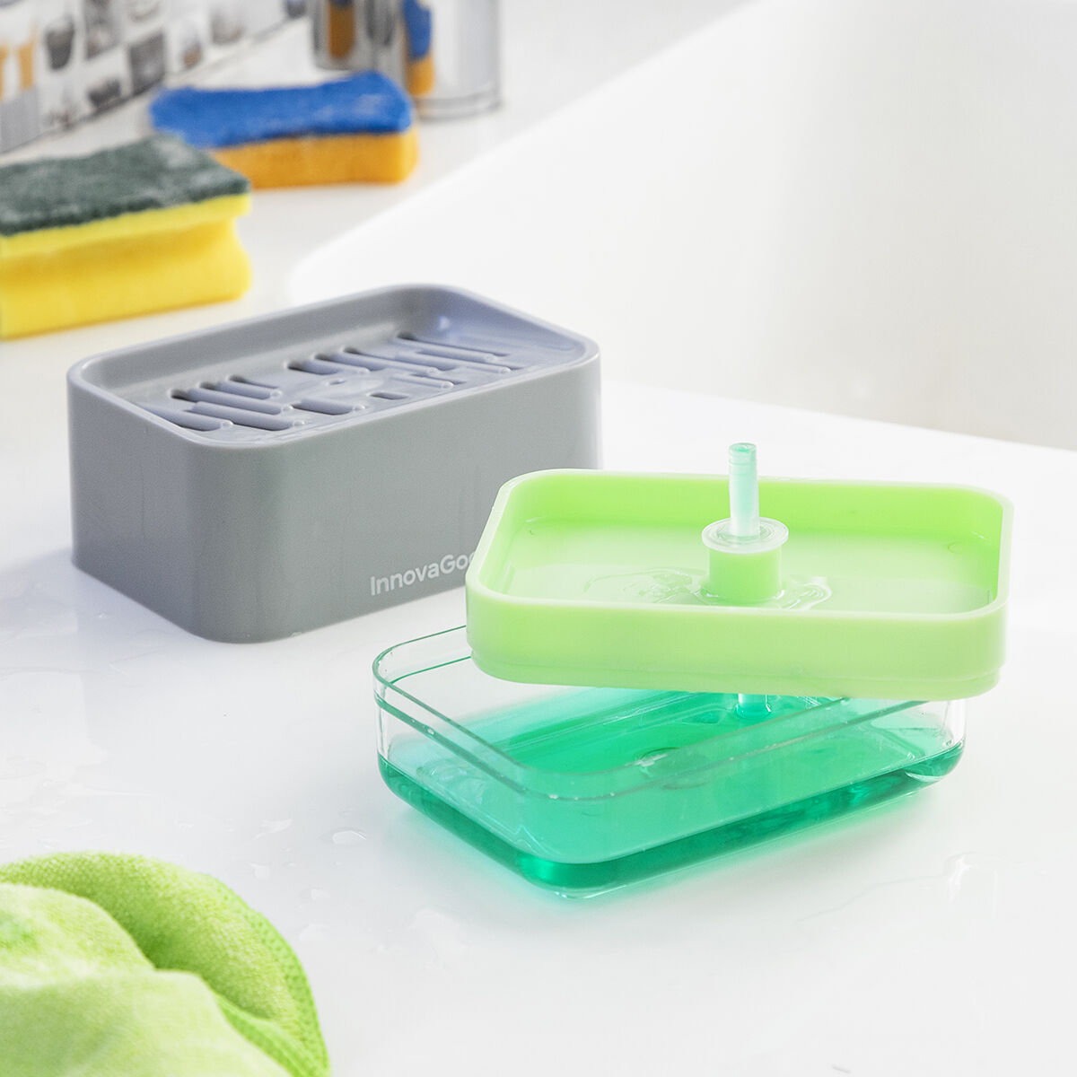The separate components of the InnovaGoods Pushoap 2-in-1 Soap Dispenser are shown, detailing its assembly and refill process. The gray top part and green-filled transparent bottom part are distinctly displayed.