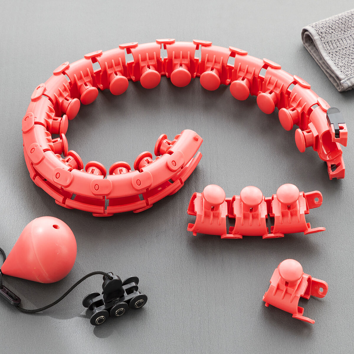 Close-up of the modular components of the Fittehoop on a flat surface, showcasing its vibrant red color and detachable nodes for easy adjustment.