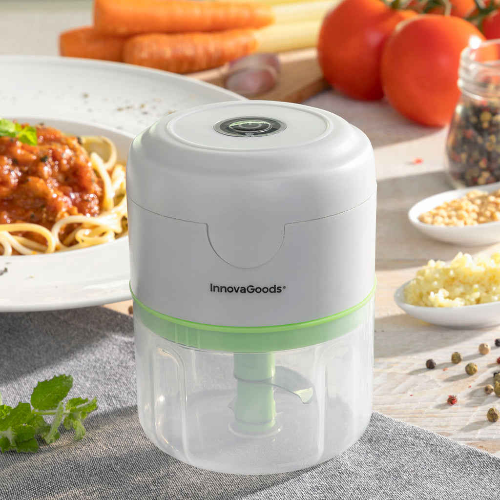 A lifestyle setting depicting the mini chopper next to a plate of spaghetti, emphasizing its role in food preparation.