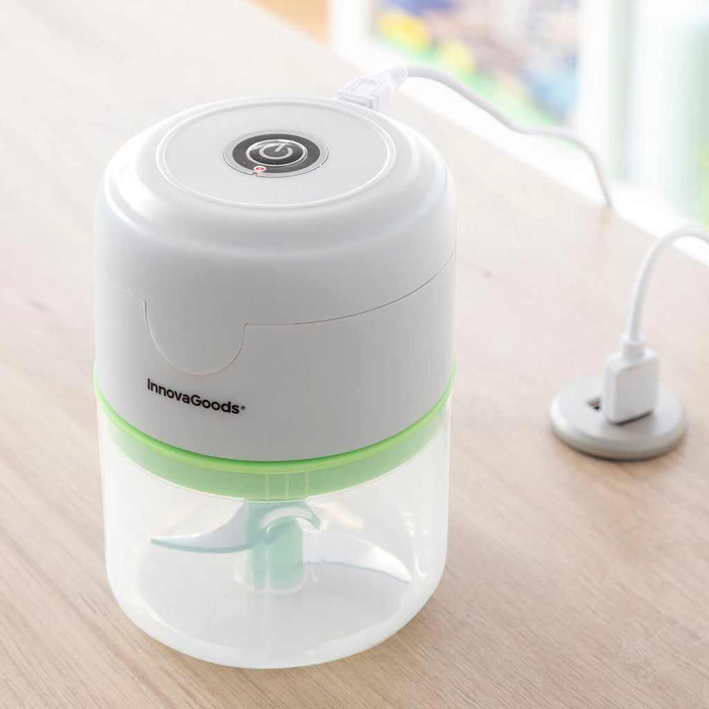 A lifestyle image portraying the mini chopper connected to a charging cable, placed on a kitchen table, highlighting its rechargeability.