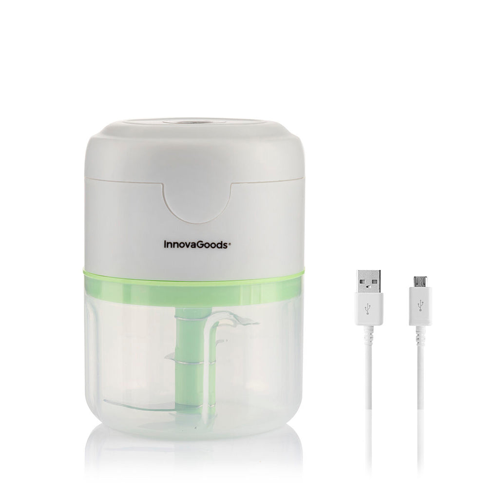 A product hero image of the InnovaGoods mini chopper alongside its USB charging cable. The clear container shows the internal blades.