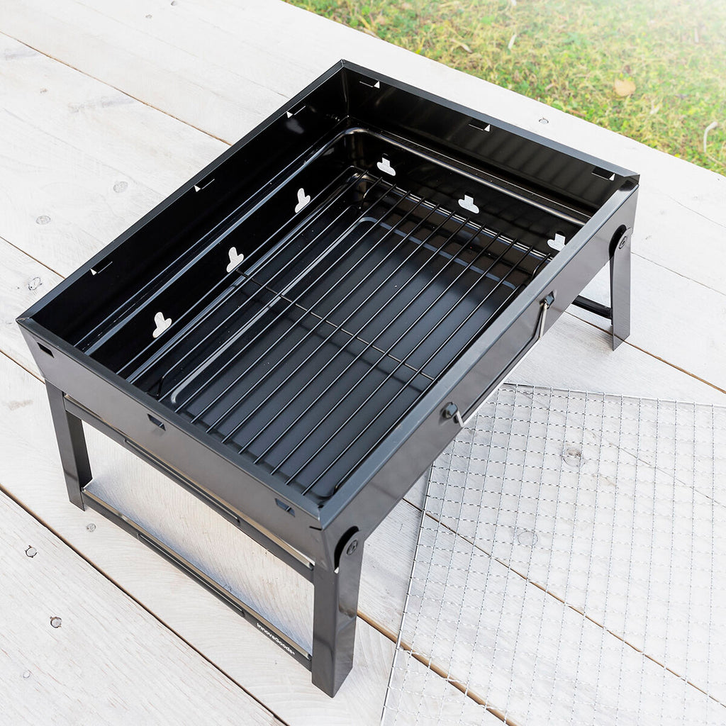 An overhead view of the grill without charcoal, showing the empty interior and its components.