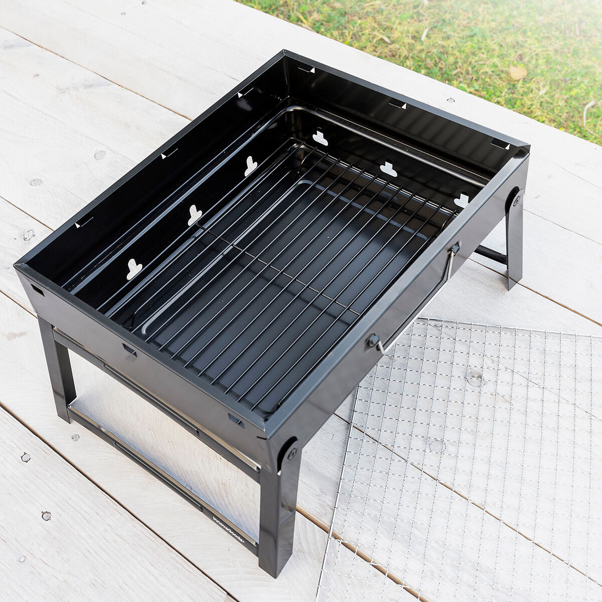 An overhead view of the grill without charcoal, showing the empty interior and its components.