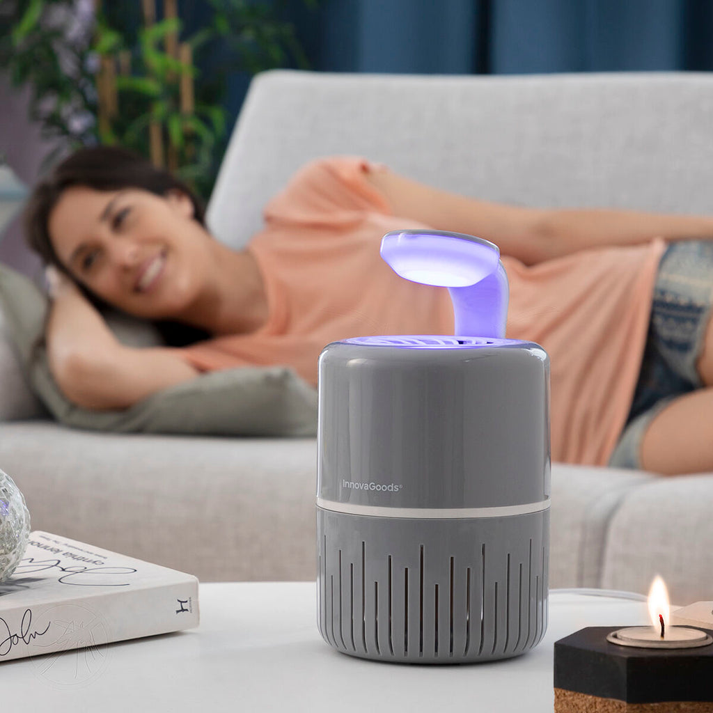 Another lifestyle image showing the lamp in a living area with a woman lounging on a couch in the background, focusing on its application in relaxing spaces.