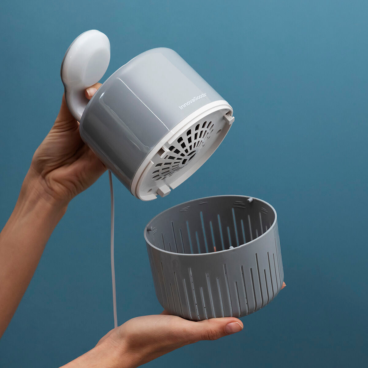 A hands-on image demonstrating the assembly or disassembly of the mosquito lamp. The top is separated from the bottom catchment area, showing the internal structure.