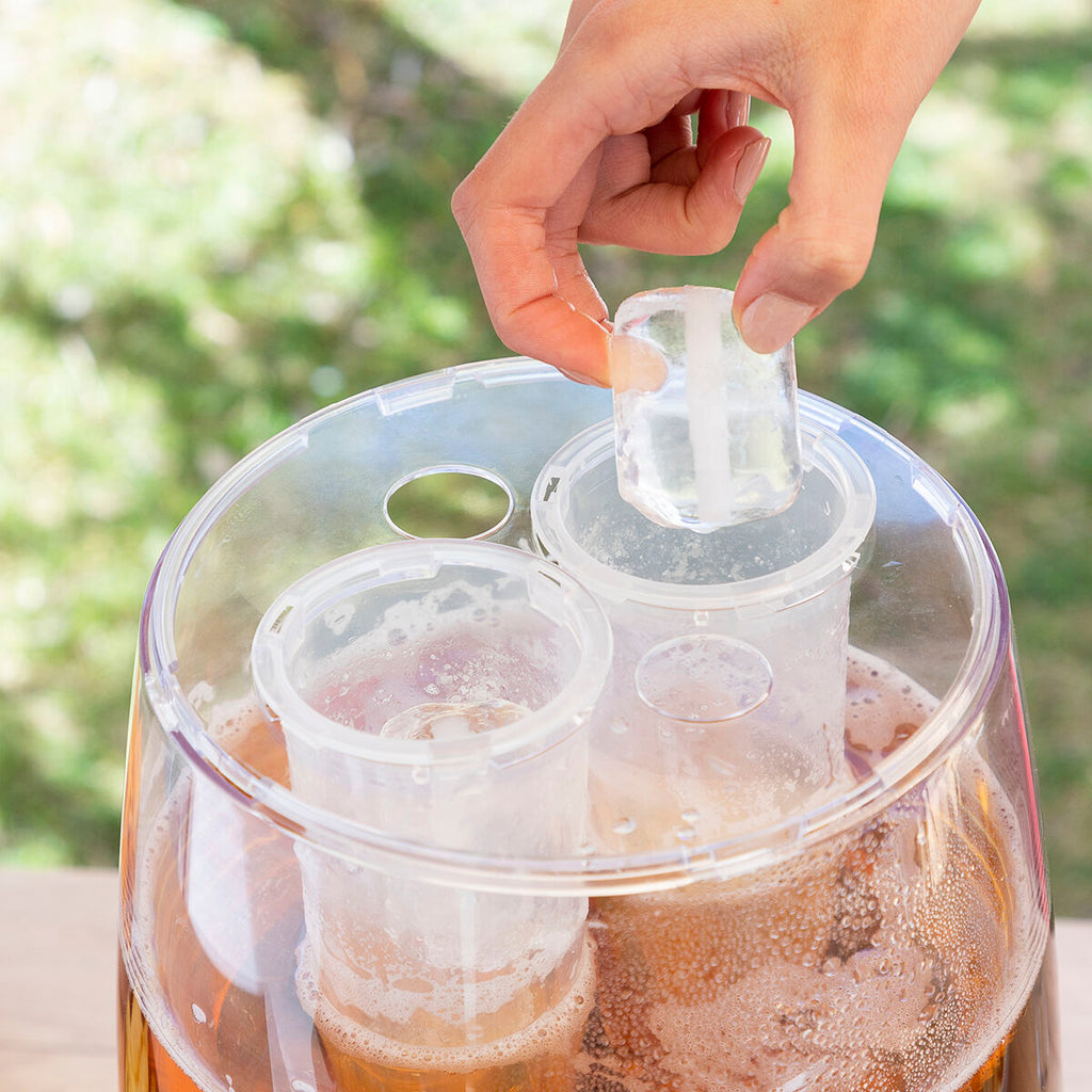 A hand removing an ice cylinder from the dispenser's compartment, highlighting the ice cooling feature.
