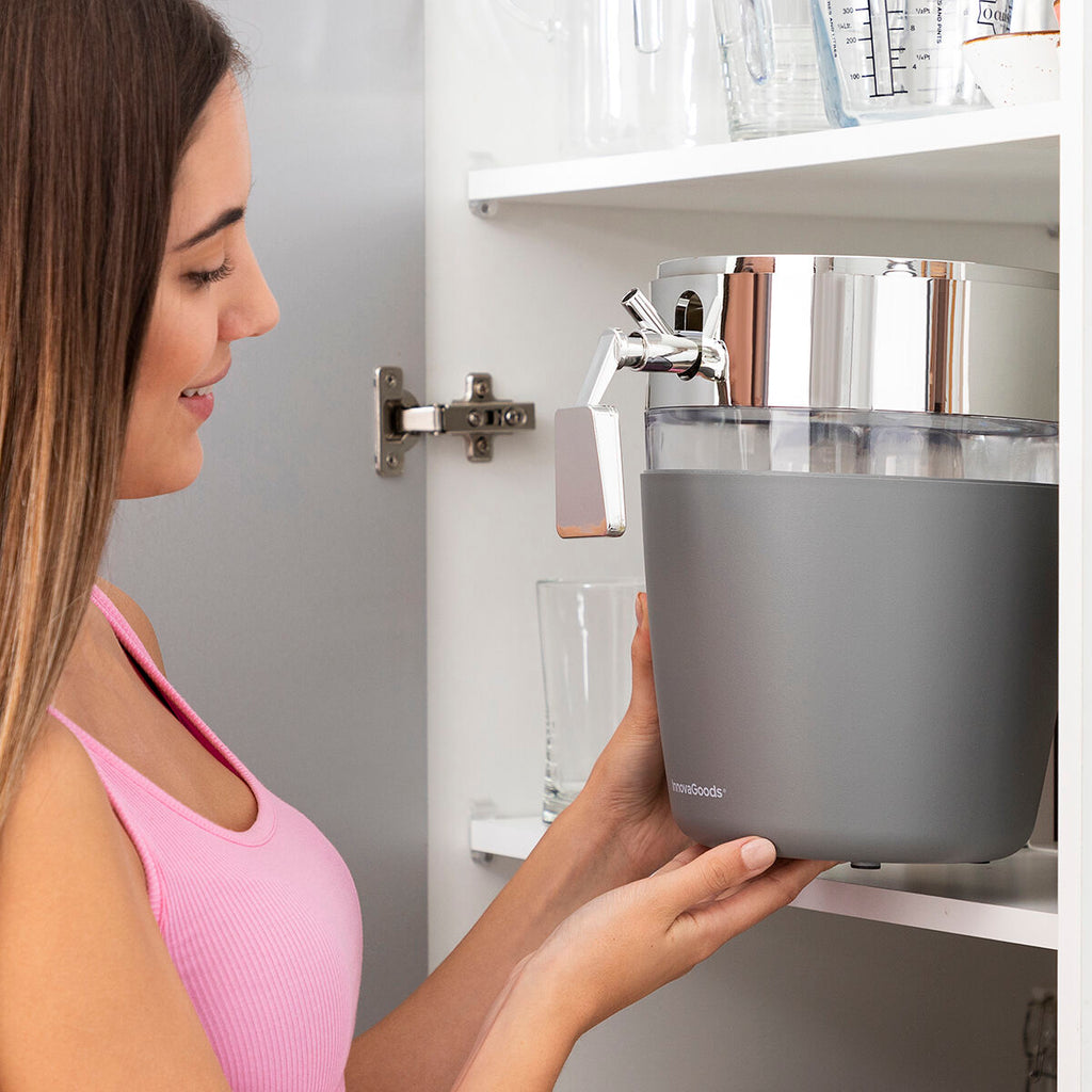 Candid shot of a person placing the dispenser in a cupboard, indicating the ease of storage. The dispenser appears empty, showing its compact size.