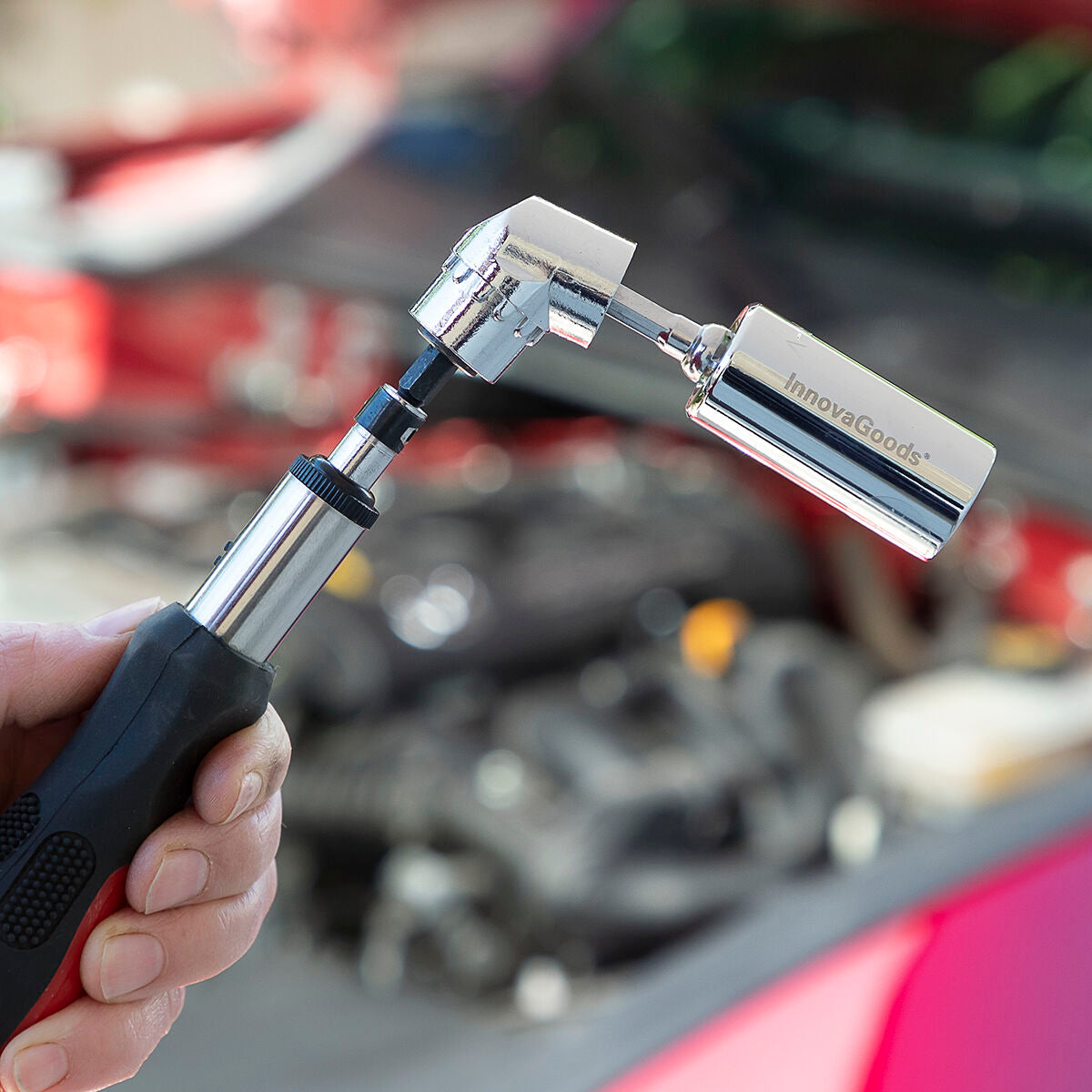 A close-up showing the socket wrench attached to a faucet, demonstrating adaptability on outdoor plumbing repairs.
