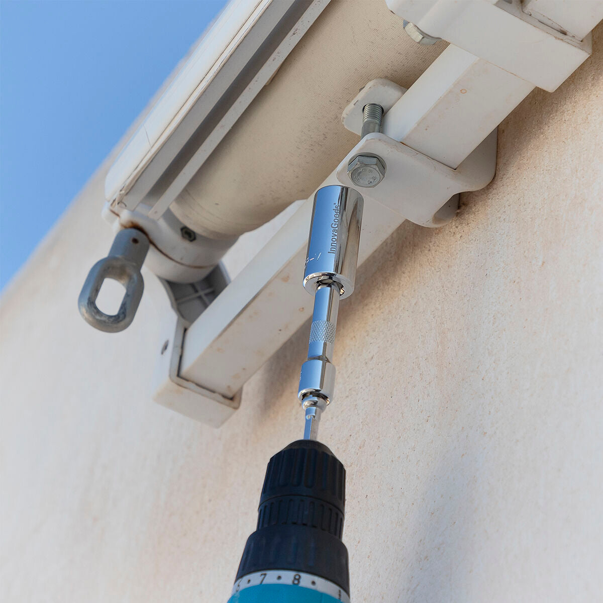The socket wrench being used on a wall fixture, demonstrating versatility on different surfaces.