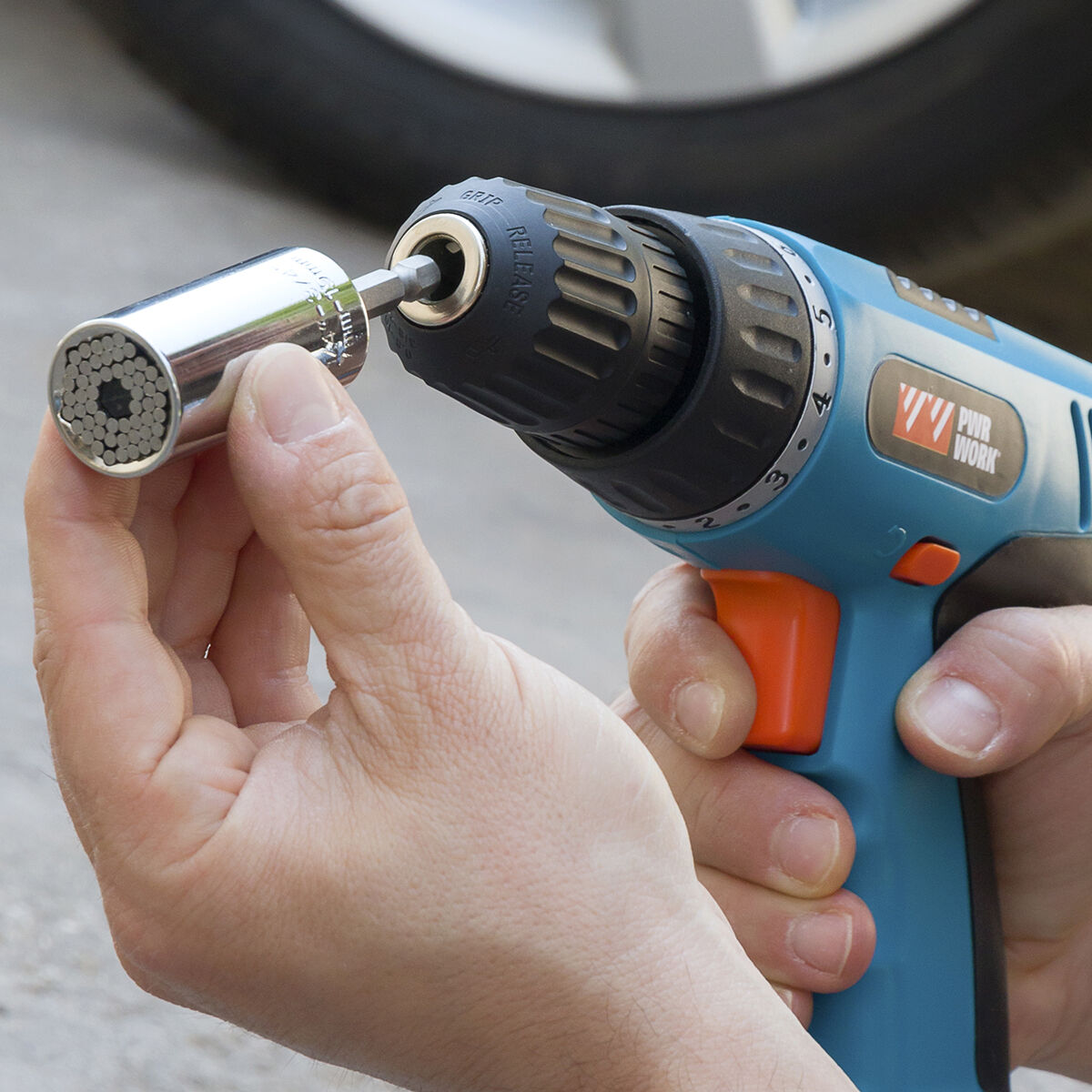 The socket wrench used with a drill, showing it in action unscrewing a bolt in a mechanical setting.