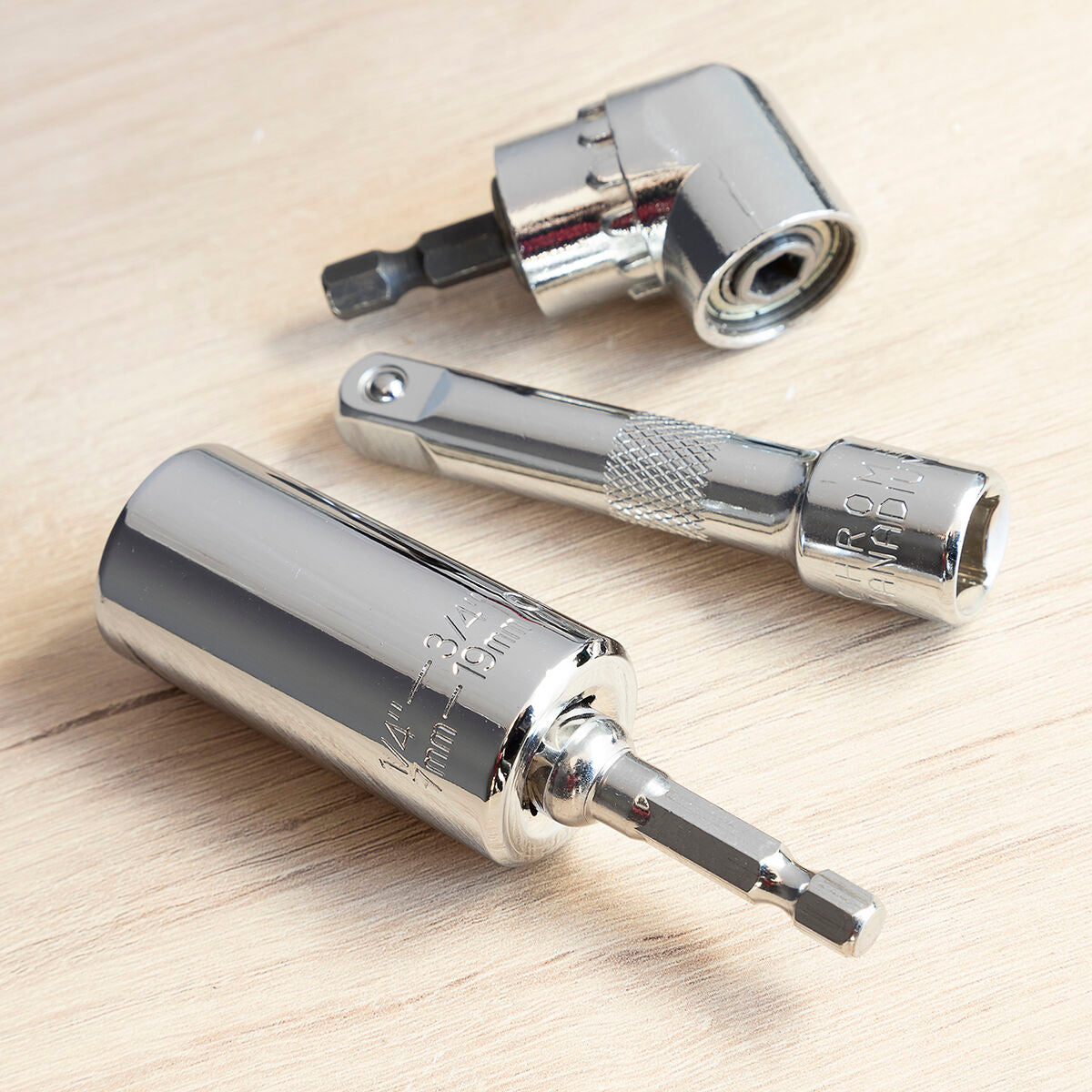 Close-up of the socket wrench and accessories on a wooden surface, emphasizing the chrome materials.