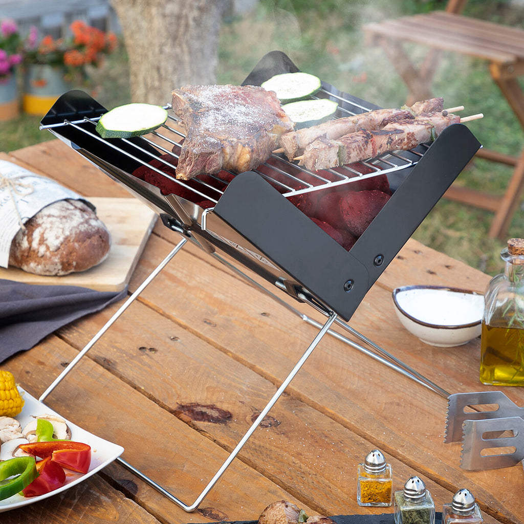A lifestyle image showcasing the barbecue in action with grilled meat and vegetables. The tabletop setup includes various side dishes and condiments, creating a homey and inviting outdoor setting.