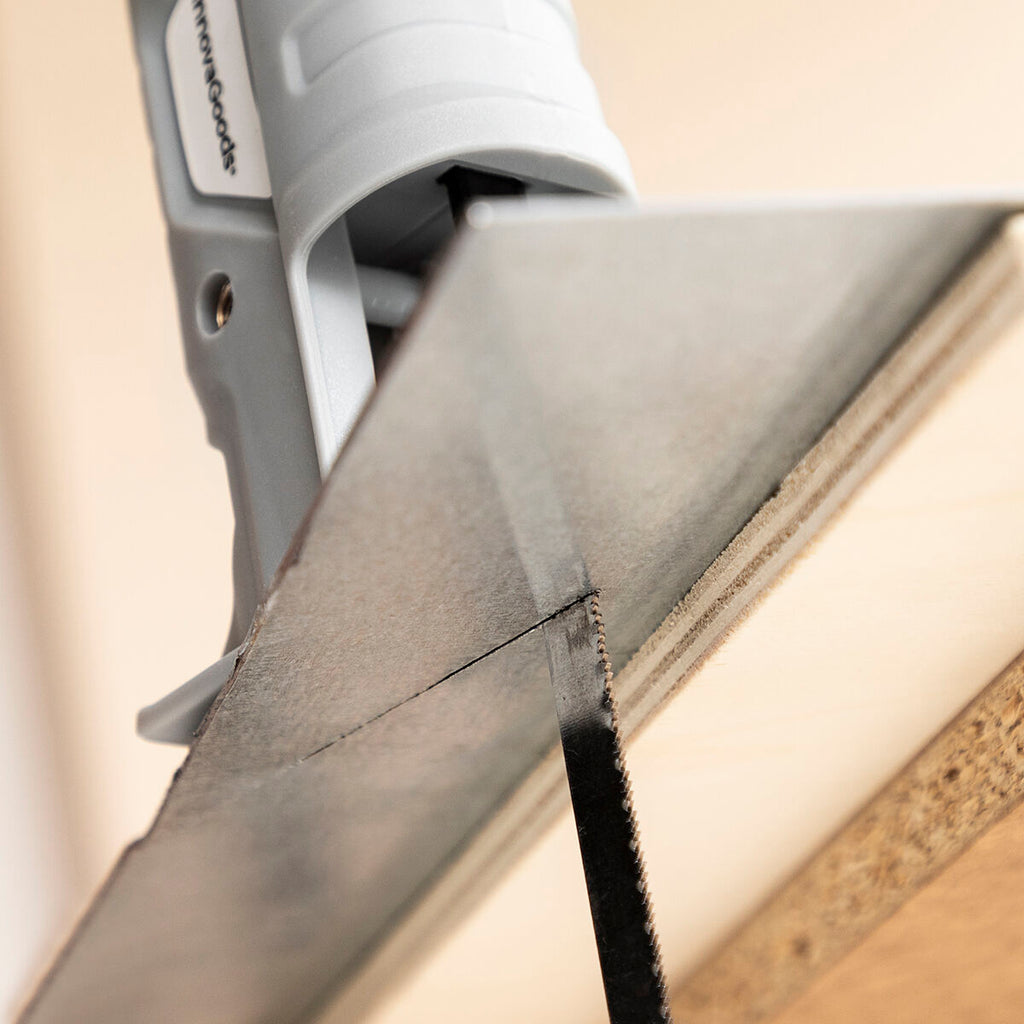 The drill attachment being used to cut metal, shot from a low angle to show the blade in action, cutting through metal smoothly.