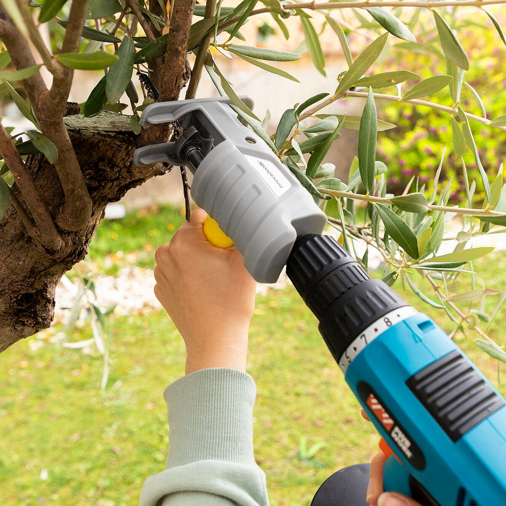 A close-up of the Jigsaw Drill Attachment in use outdoors, cutting tree branches, highlighting its versatility for garden tasks.