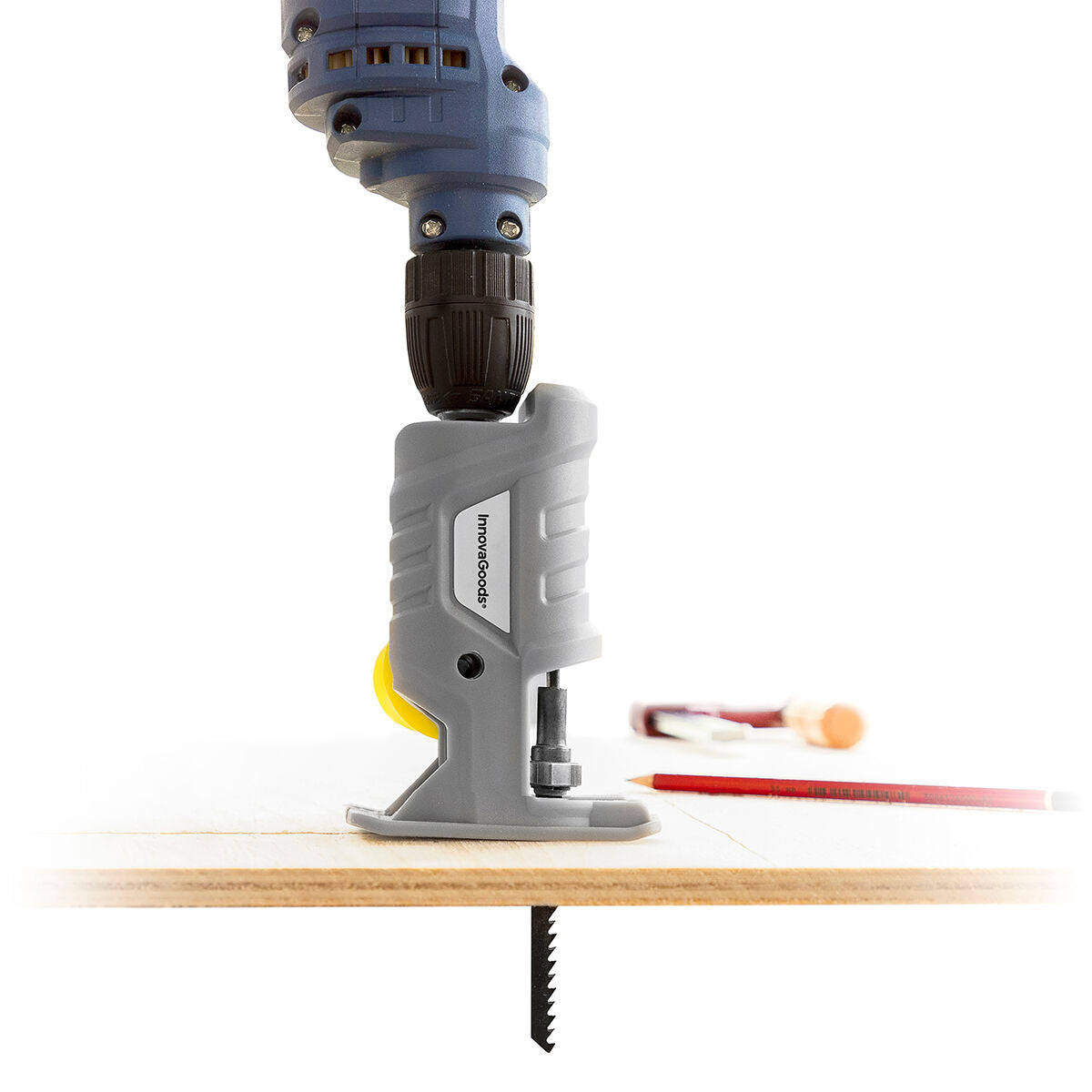 The Jigsaw Drill Attachment mounted on a drill and used to cut through a wooden board. There are other tools in the background, emphasizing a workshop setting.