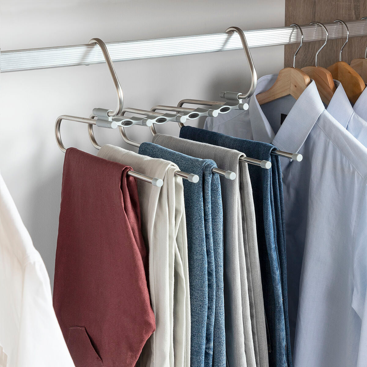 Hanger in use with various colored trousers, portrayed in an organized closet setting.