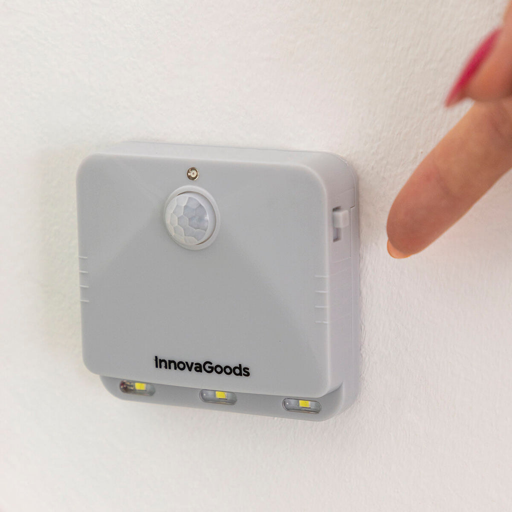 Close-up of a finger interacting with the LED motion sensor light mounted on a wall, emphasizing touch and interaction.