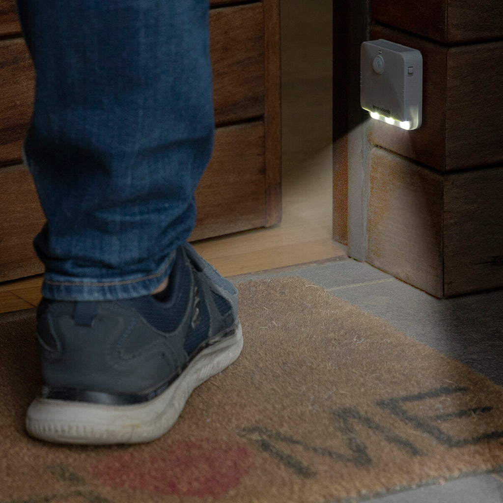 LED light installed at the entrance of a house near the door, activated by a person's foot, indicating ease of entry in the dark.
