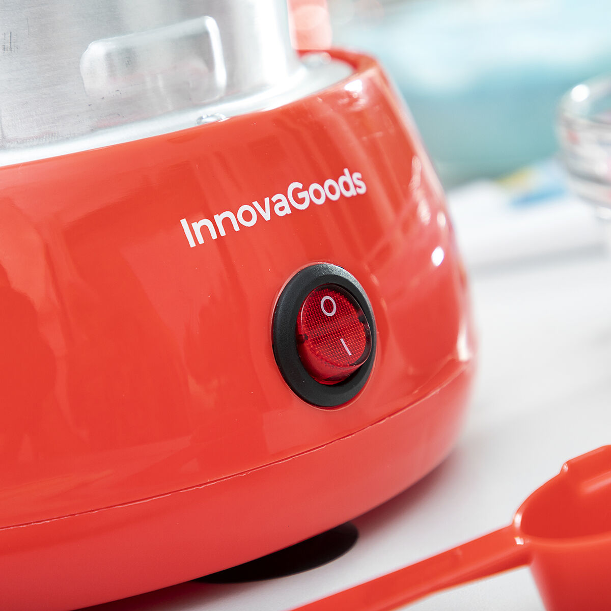 Close-up of the power button on the red base of the Candy Floss Machine Cantty InnovaGoods, showing detailed branding and material texture.