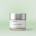 The balm is in a frosted glass jar with a matte silver lid. The label reads 'InnovaGoods Zenheal Total Repair Body Balm CBD · Shea · Sweet Almonds'. The background is a light pastel green, complementing the product's natural and soothing theme.