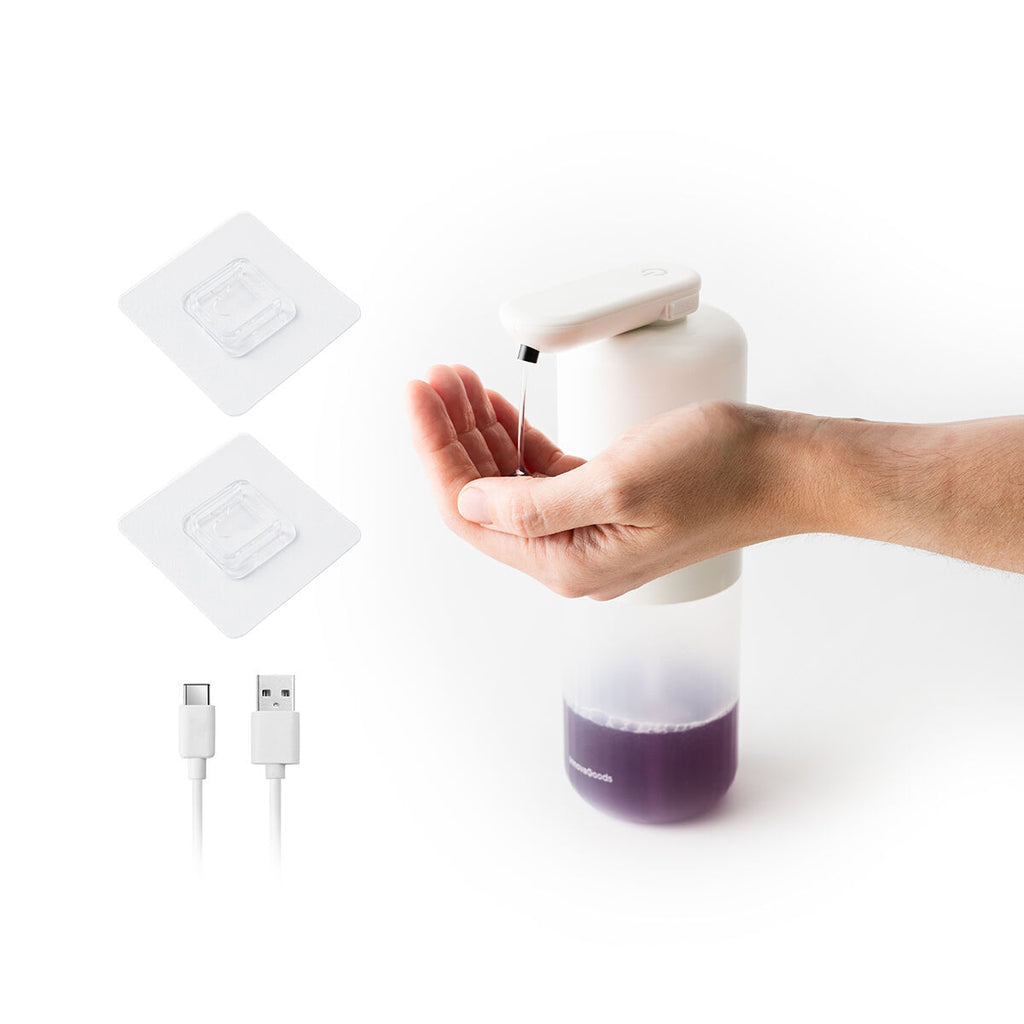The dispenser in use alongside a USB-C cable and two adhesive pads, indicating accessories included.