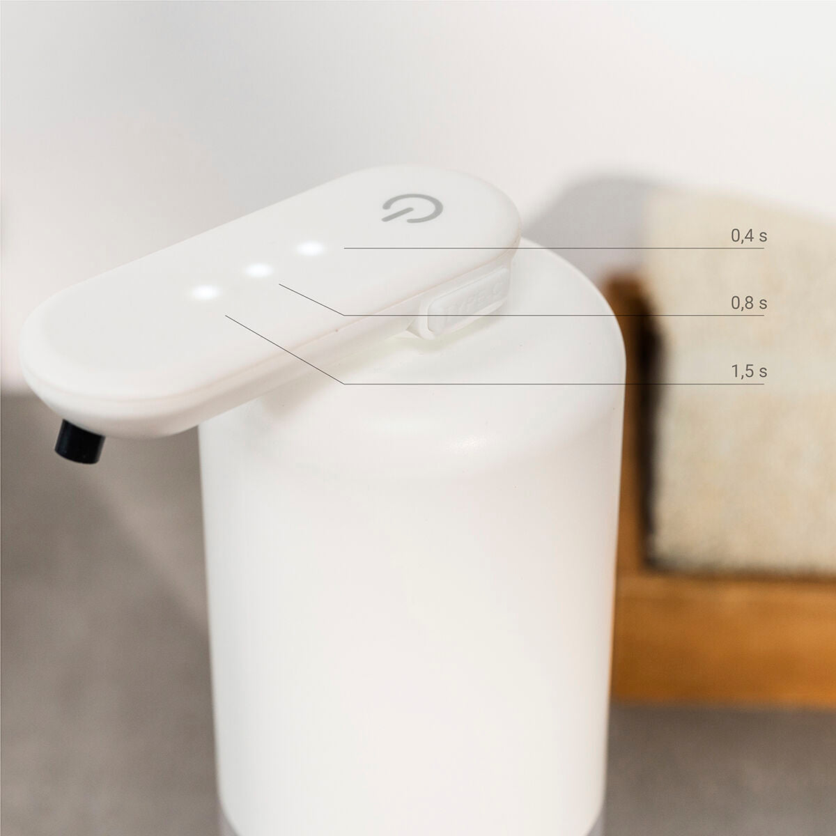 Close-up of the dispenser's touch button with three indicators, labeled with time intervals for soap dispensing duration.