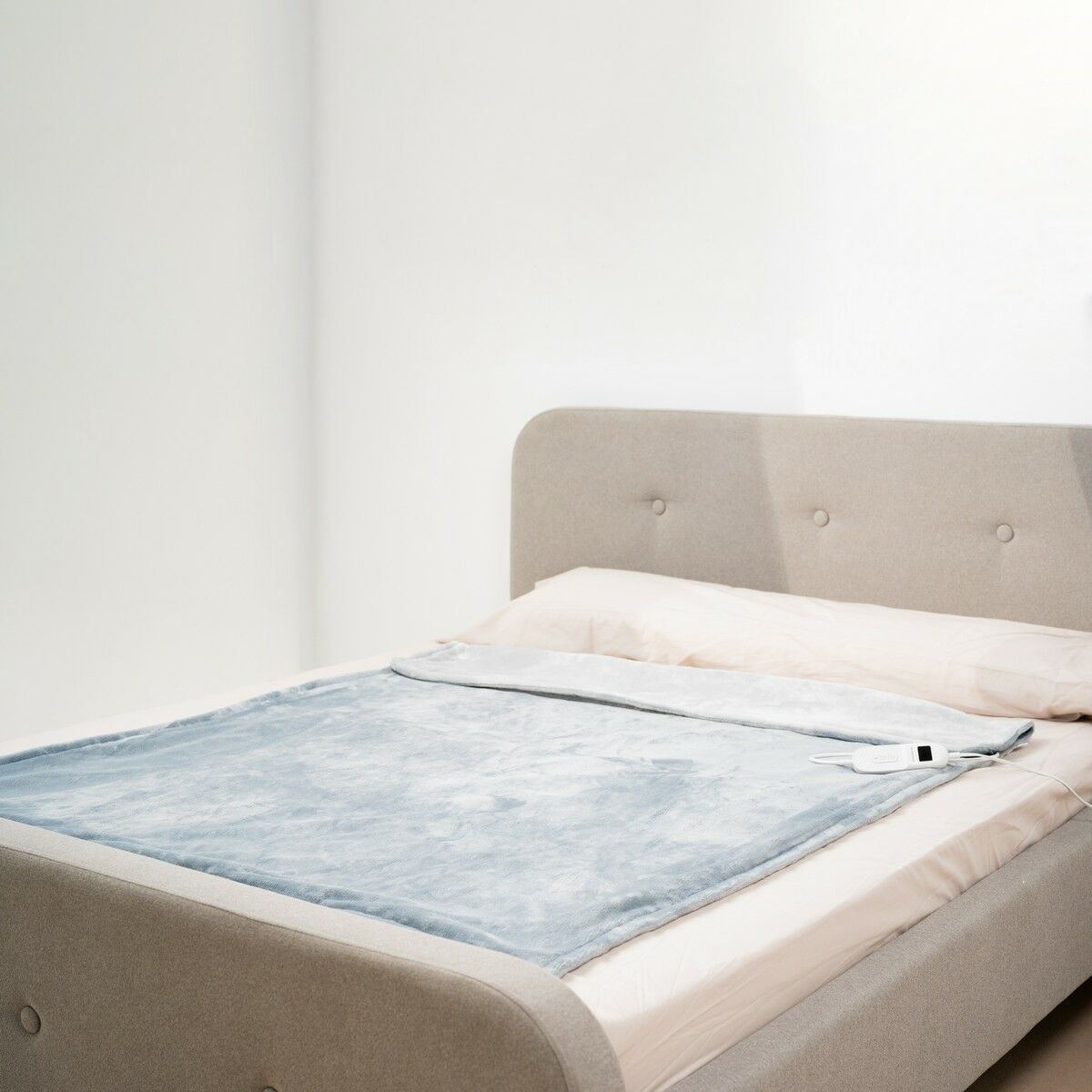 The blanket spread over a bed, showing its fit and size.