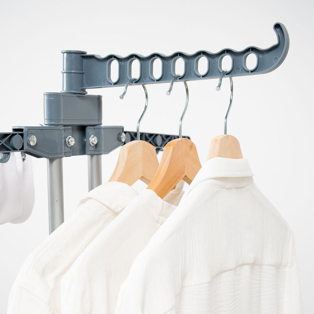 Close-up image showcasing the hanger support arm of the dryer, with wooden hangers holding white shirts, highlighting the product's practical features.
