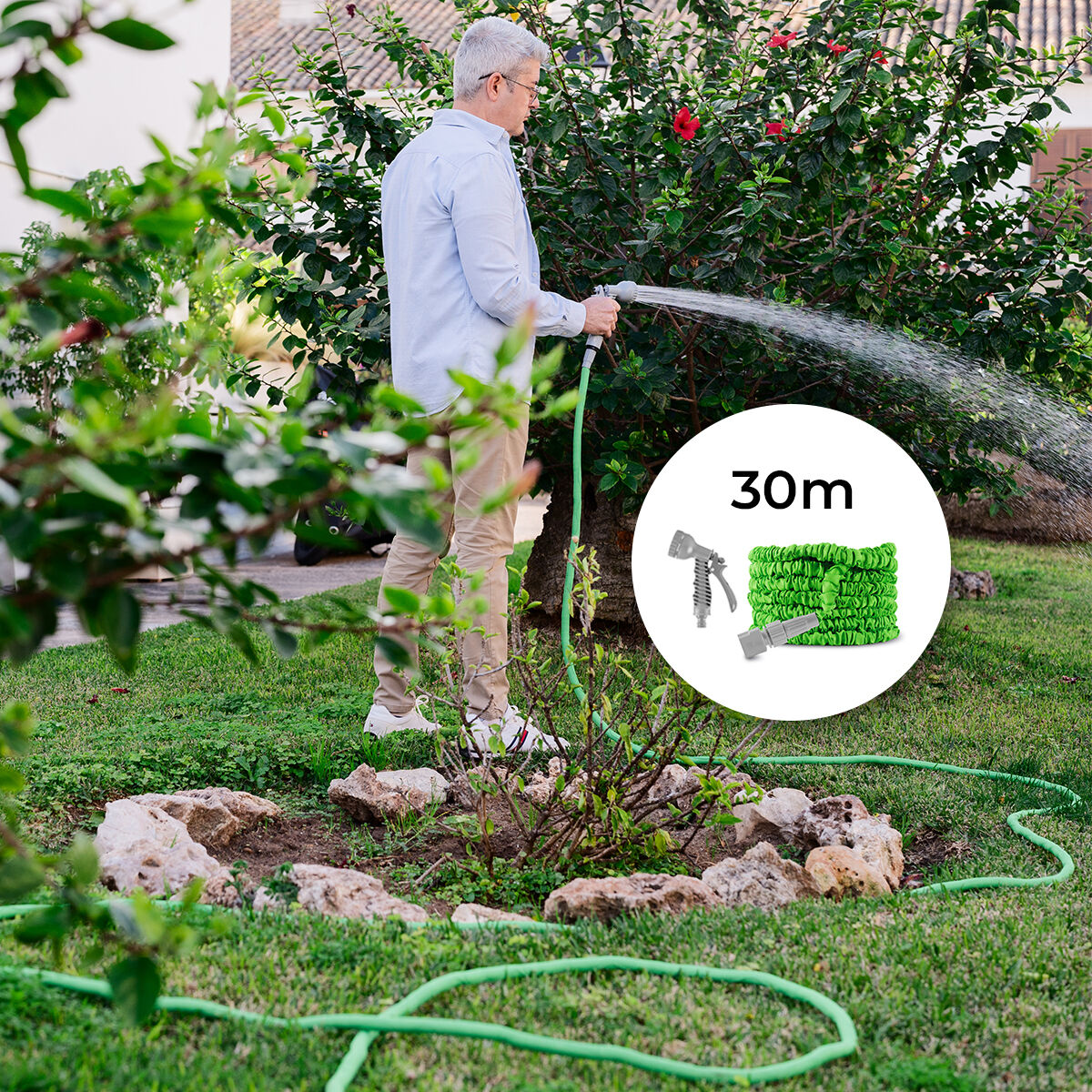 A person watering a garden, using a green expandable hose with a grey spray nozzle. The scene shows a lush garden setting, with a transparent water spray. A product image of the hose coiled up is inset, with a length indication of 30m.