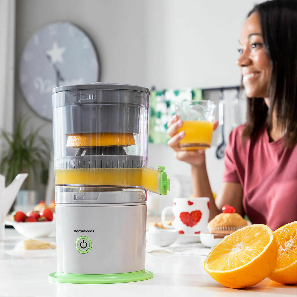 Juicer in use with a person drinking juice in a kitchen setting.